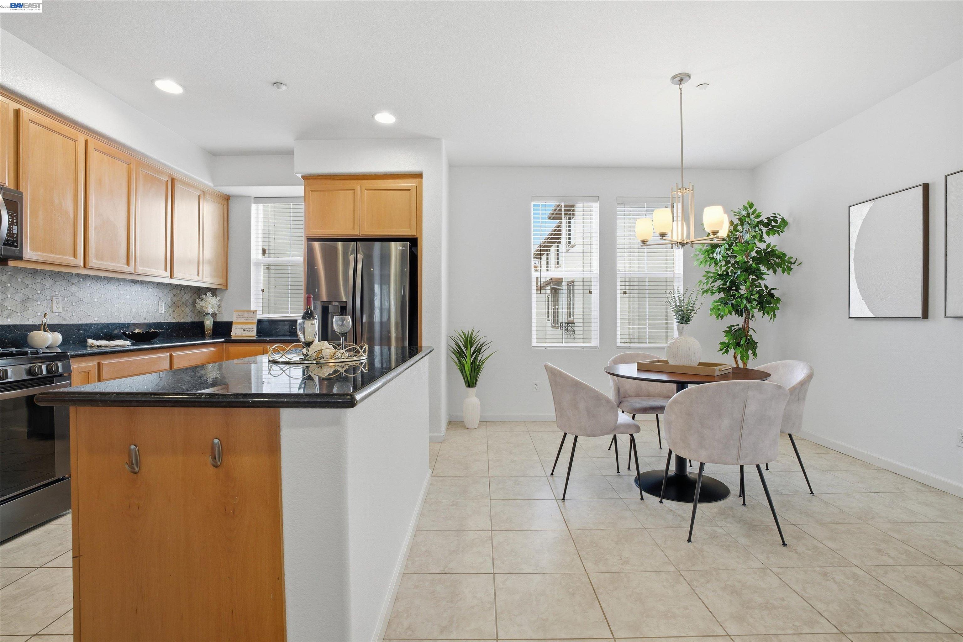 2833 Alnwick Avenue, Unit 7 Livermore, CA 94551 - Photo 17 of 37 a kitchen with stainless steel appliances granite countertop a sink a stove a refrigerator a dining table and chairs with wooden floor