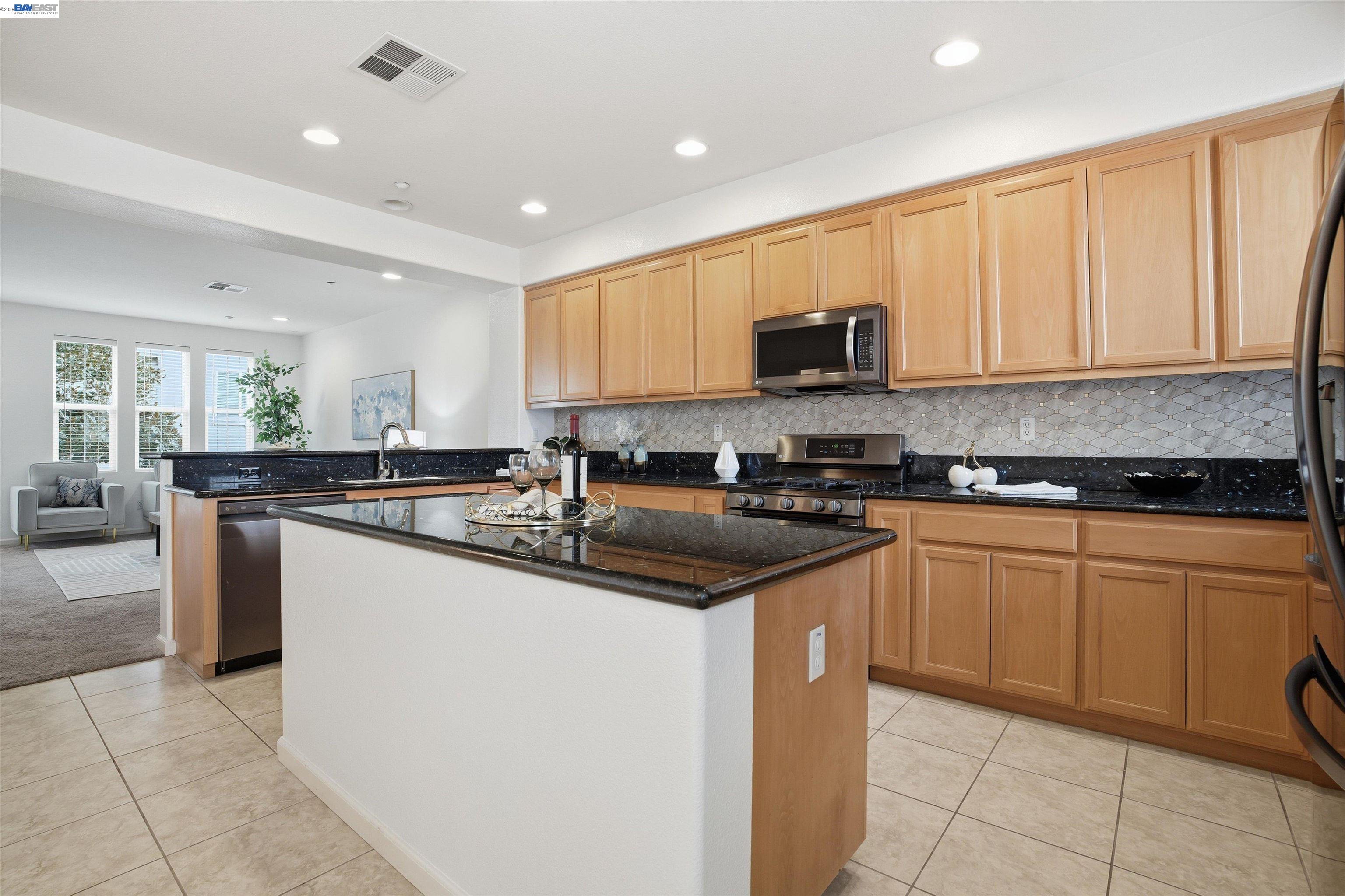 2833 Alnwick Avenue, Unit 7 Livermore, CA 94551 - Photo 19 of 37 a kitchen with stainless steel appliances granite countertop a sink counter space cabinets and a large window