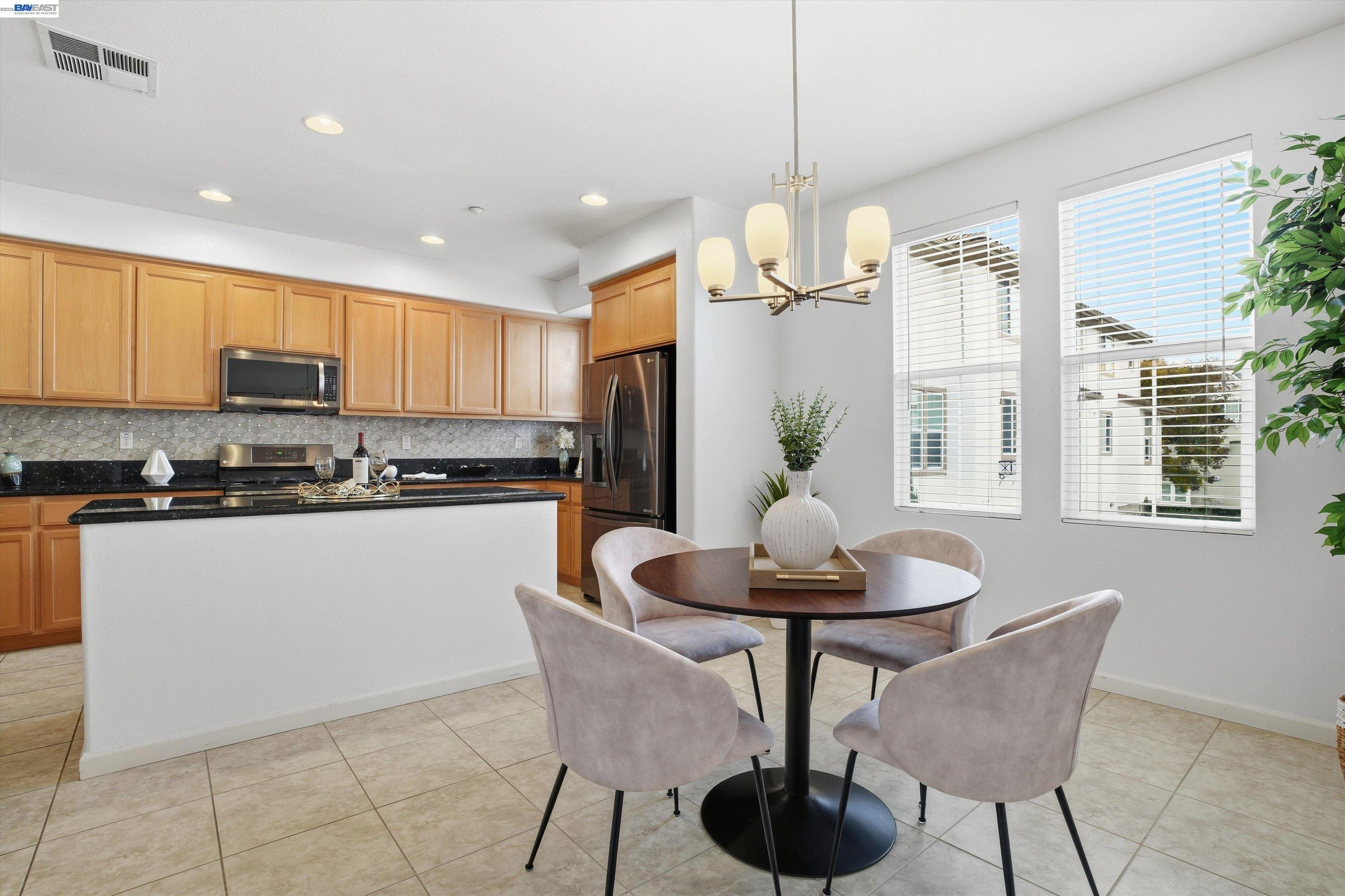 2833 Alnwick Avenue, Unit 7 Livermore, CA 94551 - Photo 23 of 37 a kitchen with stainless steel appliances a dining table chairs and granite counter tops