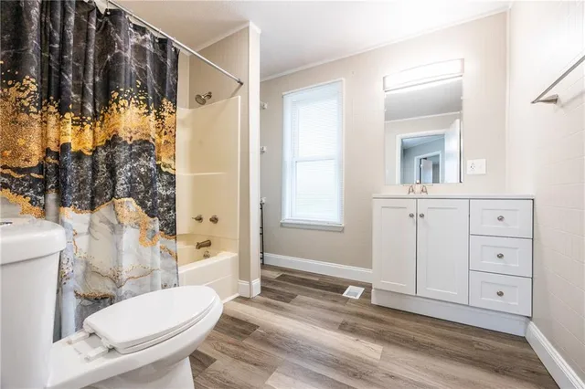 a bathroom with a sink a toilet a mirror and shower