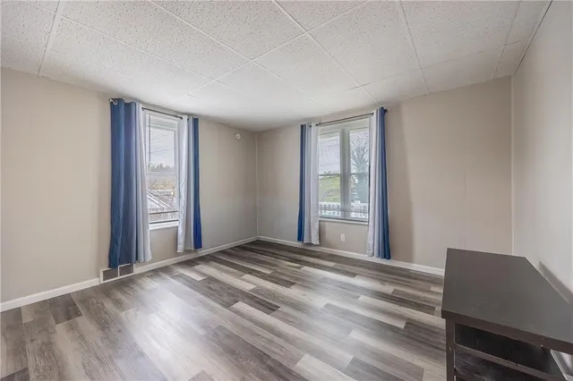a view of a room with wooden floor and windows
