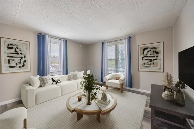 a living room with furniture a flat screen tv and a large window