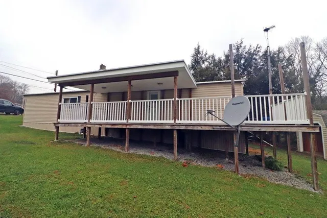 a view of house with a yard and deck