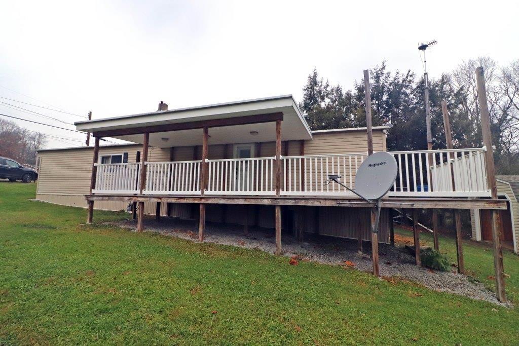 a view of house with a yard and deck