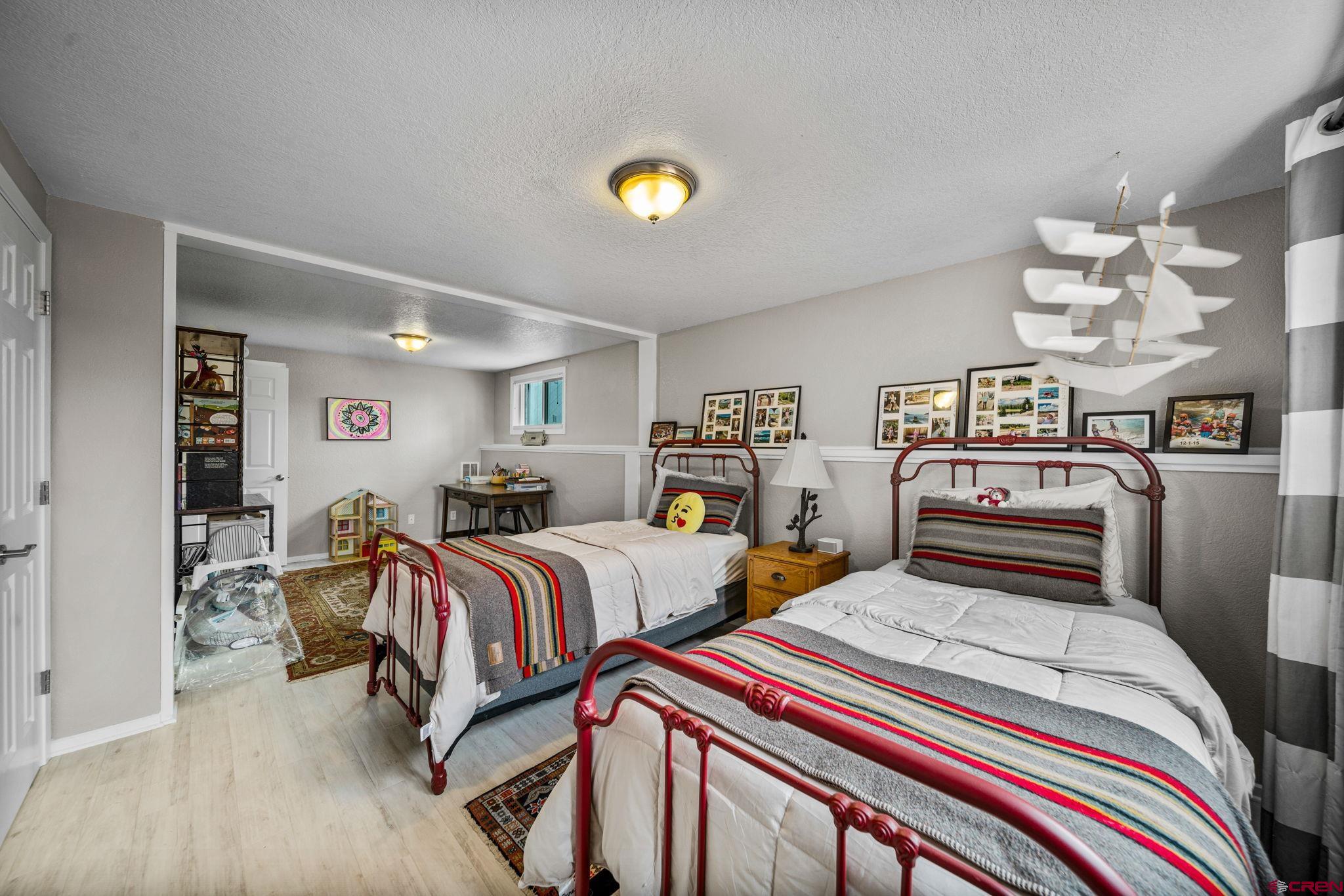 25 Highland Place Durango, CO 81301 - Photo 26 of 40 a bedroom with two beds and a chandelier