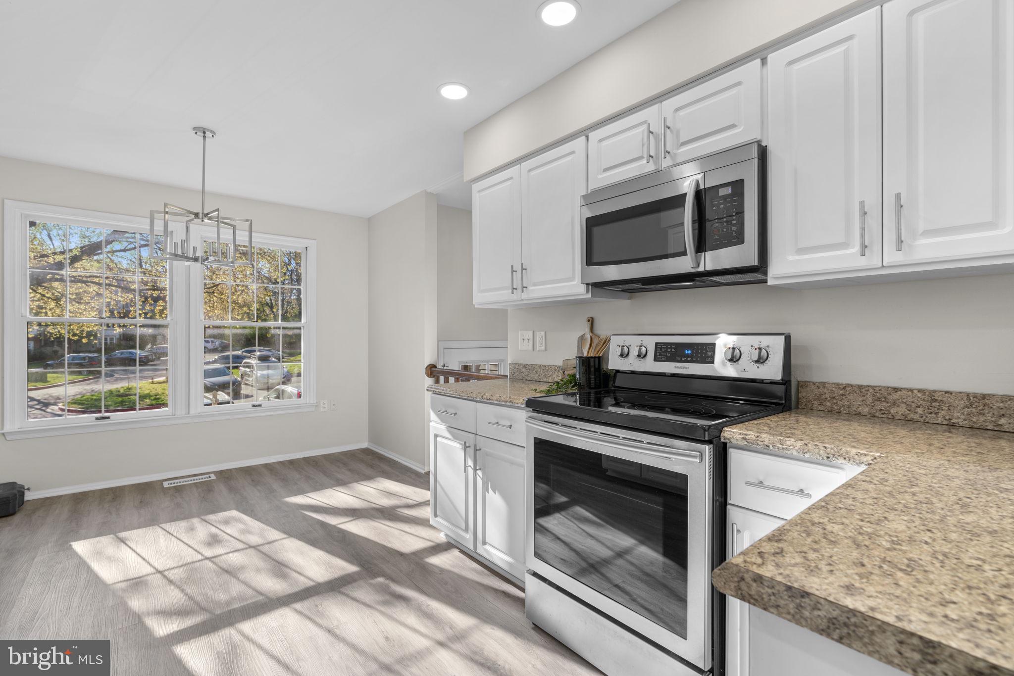 7525 Swan Point Way, Unit 195 Columbia, MD 21045 - Photo 11 of 30 a kitchen with stainless steel appliances granite countertop a stove microwave and cabinets