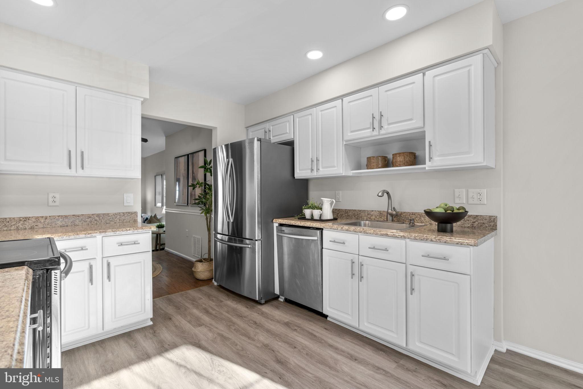 7525 Swan Point Way, Unit 195 Columbia, MD 21045 - Photo 13 of 30 a kitchen with white cabinets and stainless steel appliances