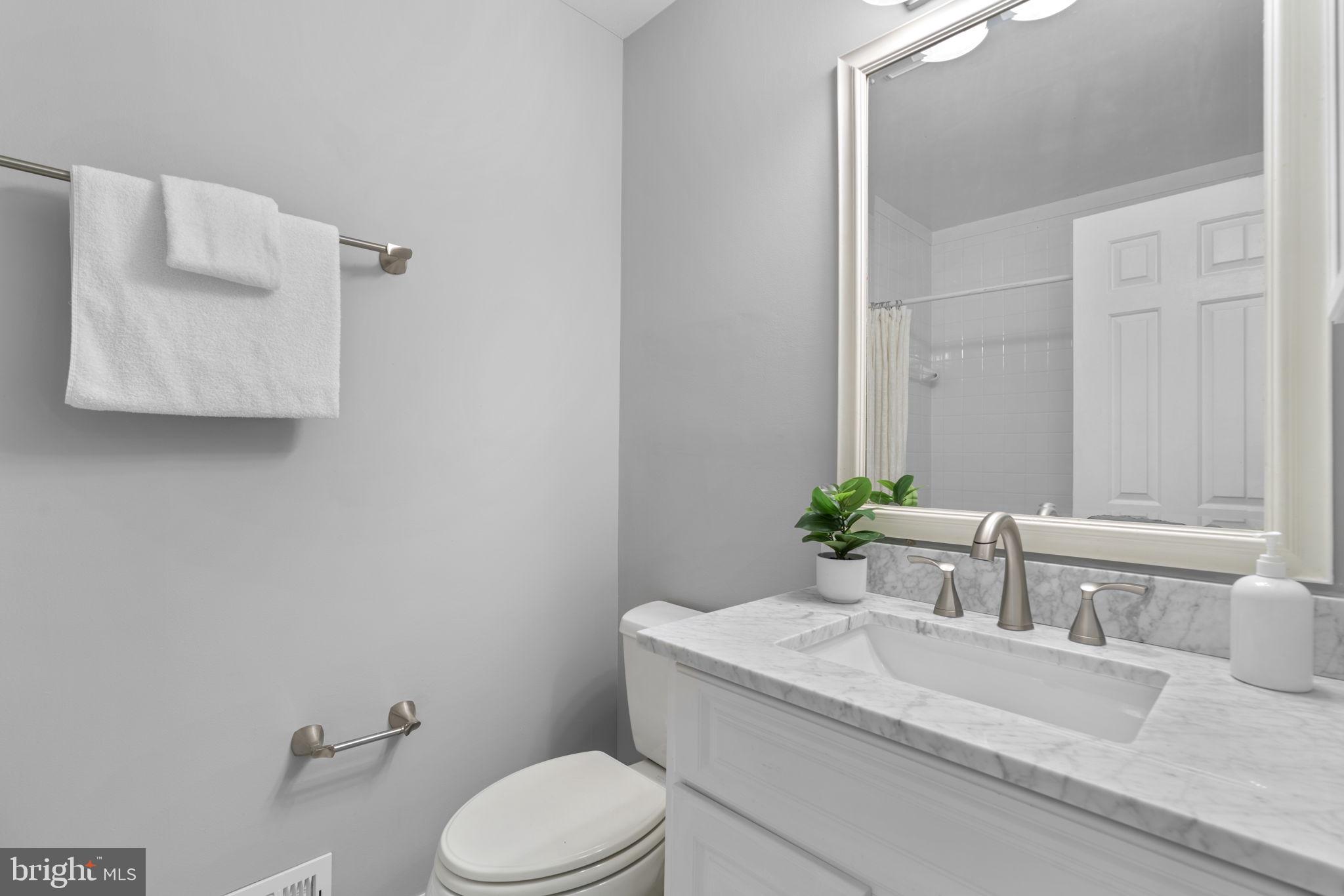 7525 Swan Point Way, Unit 195 Columbia, MD 21045 - Photo 21 of 30 a bathroom with a granite countertop toilet sink and mirror