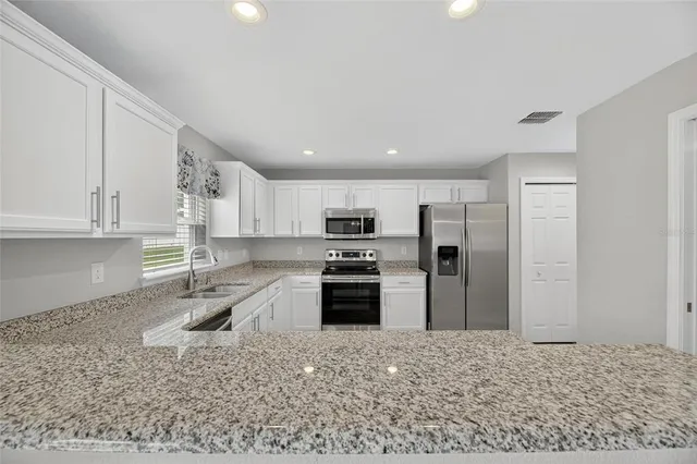 a spacious bathroom with a granite countertop sink and a mirror