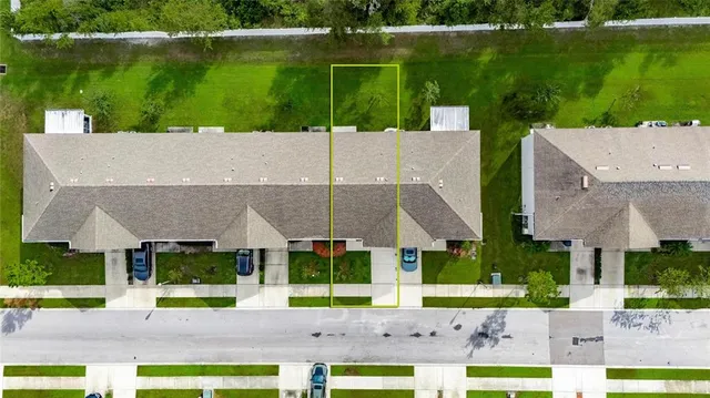 an aerial view of a house with a yard basket ball court and parked cars
