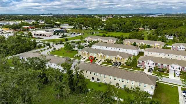 an aerial view of a house with a yard and large tree