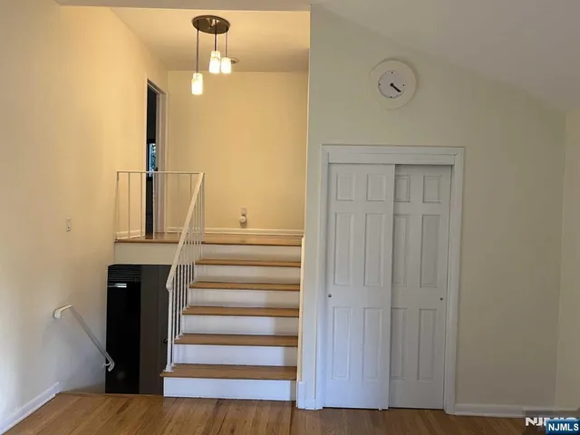 a view of a hallway with wooden floor and entryway