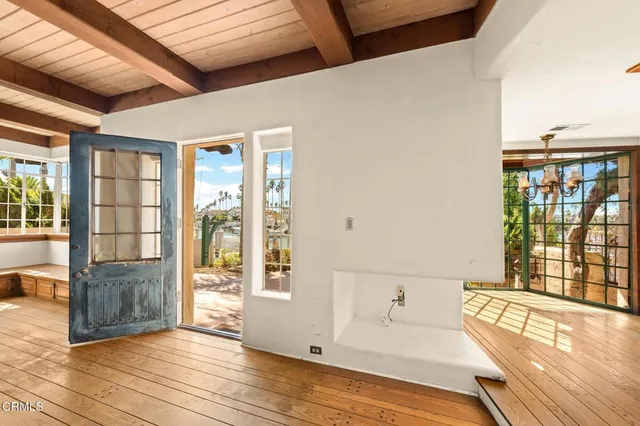 a view of a hallway with wooden floor and chandelier