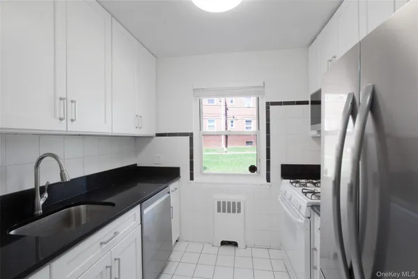 a kitchen with a refrigerator sink and cabinets