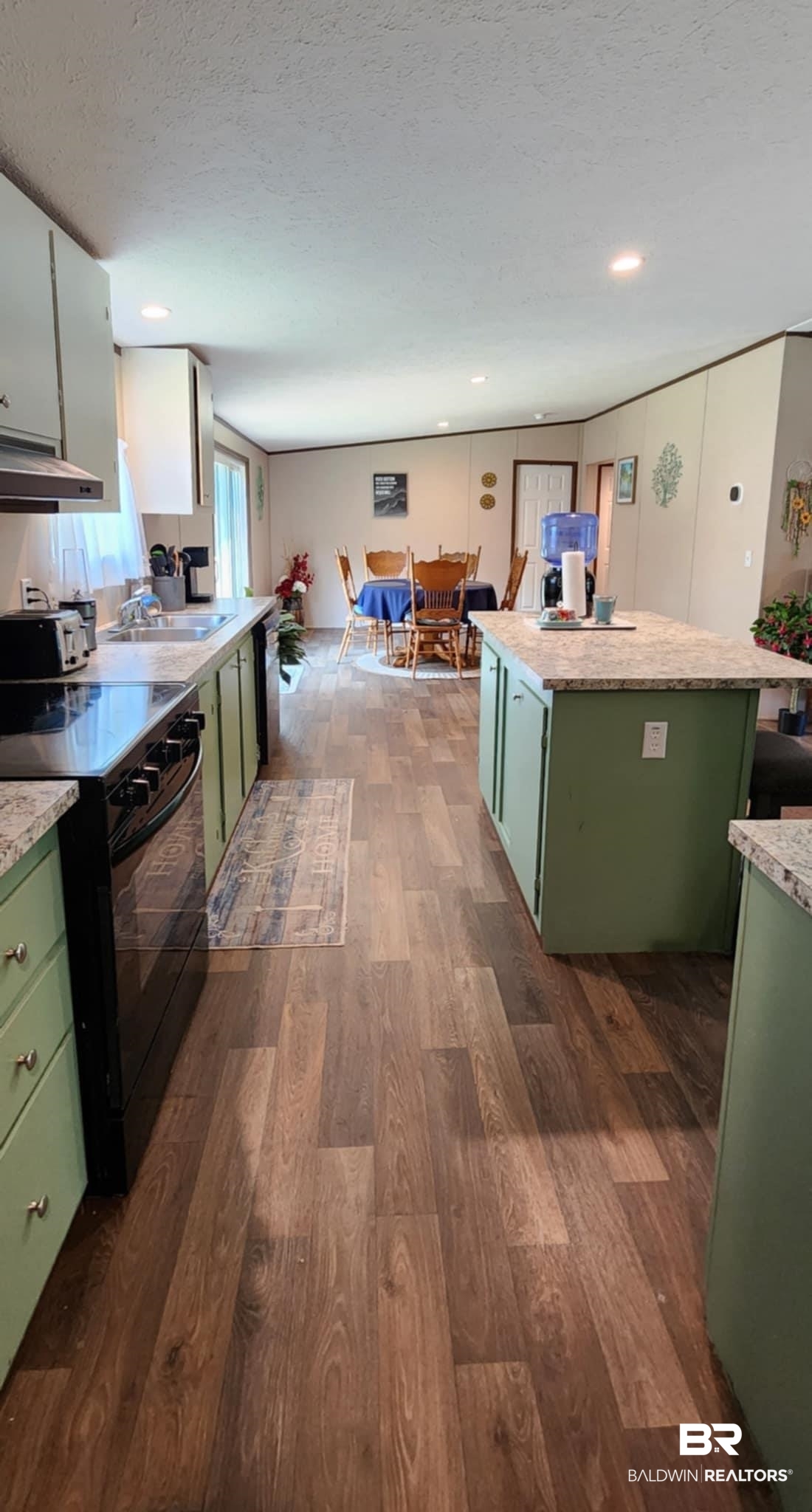 25474 Waterworld Road Robertsdale, AL 36567 - Photo 10 of 30 Kitchen featuring green cabinets, black electric range oven, a textured ceiling, and dark wood-style floors
