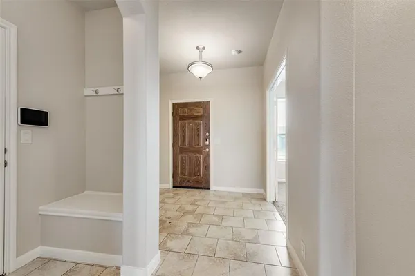 a view of a hallway with wooden floor and a bathroom