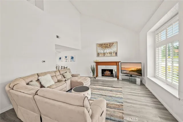 a living room with furniture a fireplace and next to a window