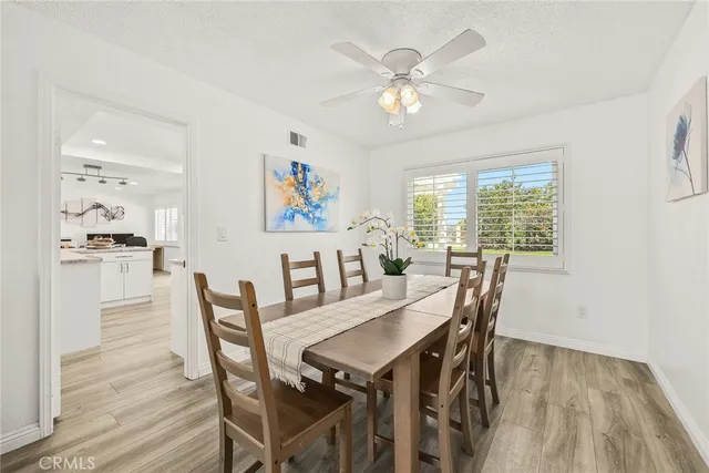 a view of a dining room with furniture a chandelier and wooden floor