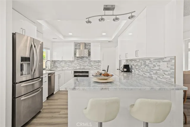 a kitchen with stainless steel appliances granite countertop a sink refrigerator stove and microwave