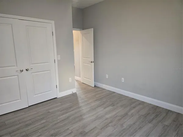 a view of an empty room with wooden floor