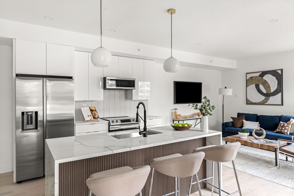 a kitchen with stainless steel appliances kitchen island a table and chairs in it
