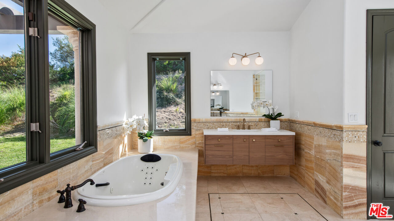 27311 Winding Way Malibu, CA 90265 - Photo 38 of 73 a bathroom with a tub sink and mirror