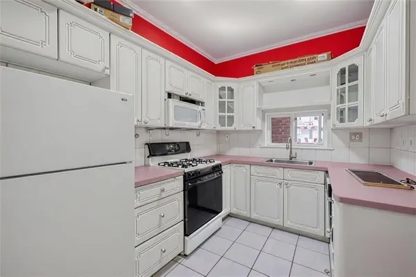 a kitchen with white cabinets and white appliances