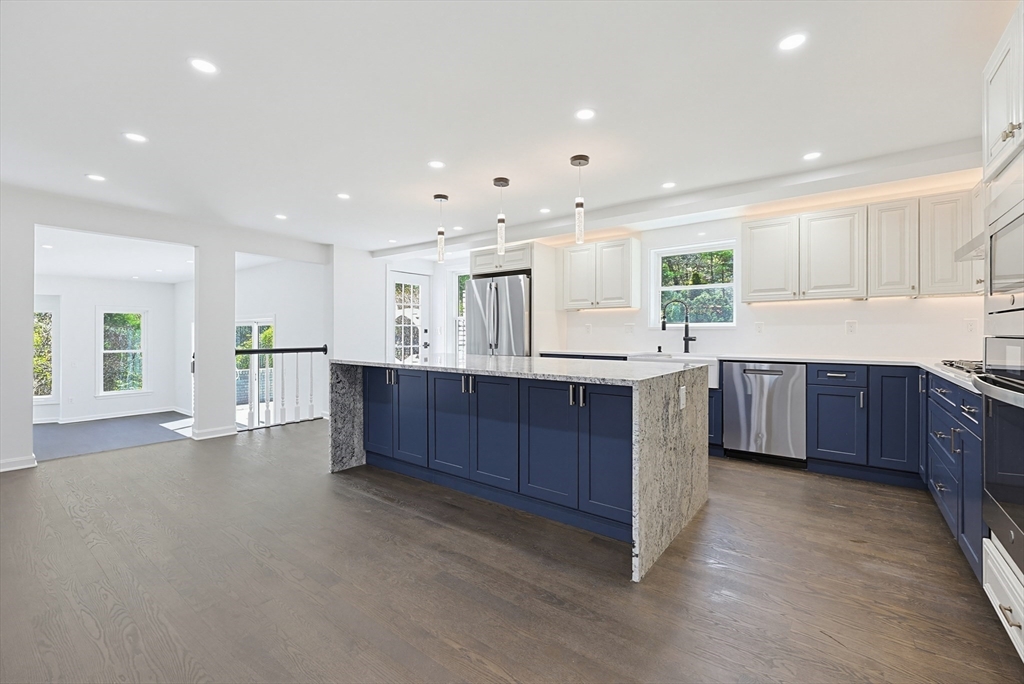 175 Pleasant Street Upton, MA 01568 - Photo 12 of 39 a large kitchen with a large counter top a sink stainless steel appliances and cabinets