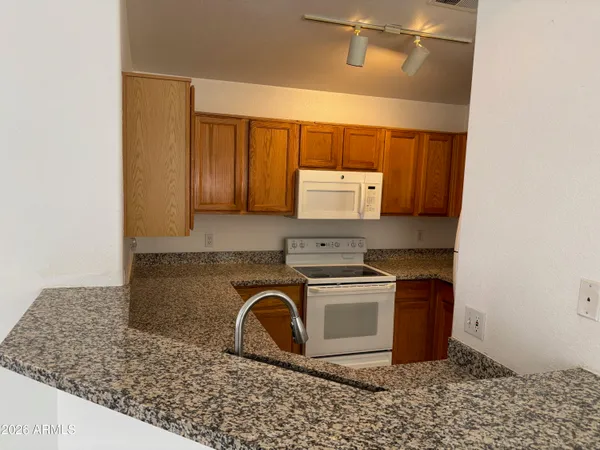 a kitchen with stainless steel appliances granite countertop a stove a sink and a microwave