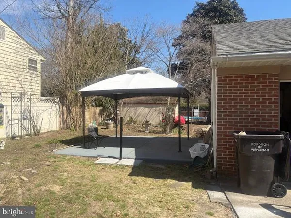a view of a patio with a table and chairs under an umbrella