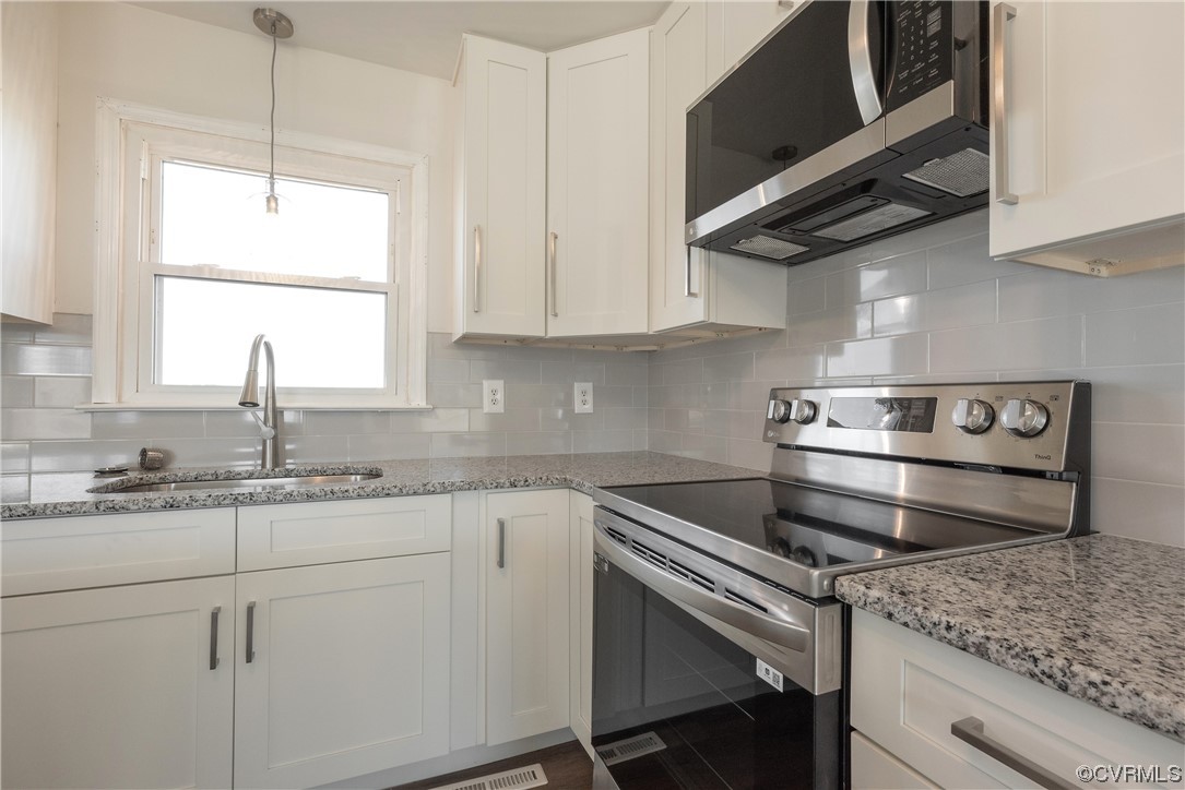 320 Courtney Road Lancaster, VA 22503 - Photo 12 of 43 a kitchen with a stove cabinets and a window