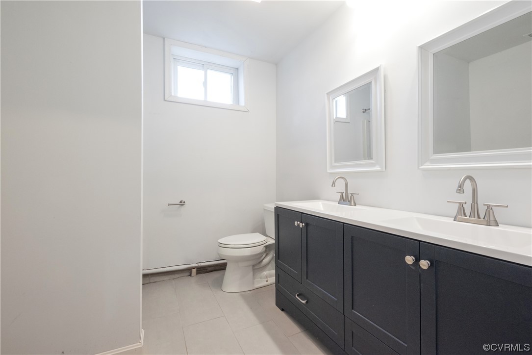 320 Courtney Road Lancaster, VA 22503 - Photo 28 of 43 a bathroom with a toilet a sink a vanity and mirror