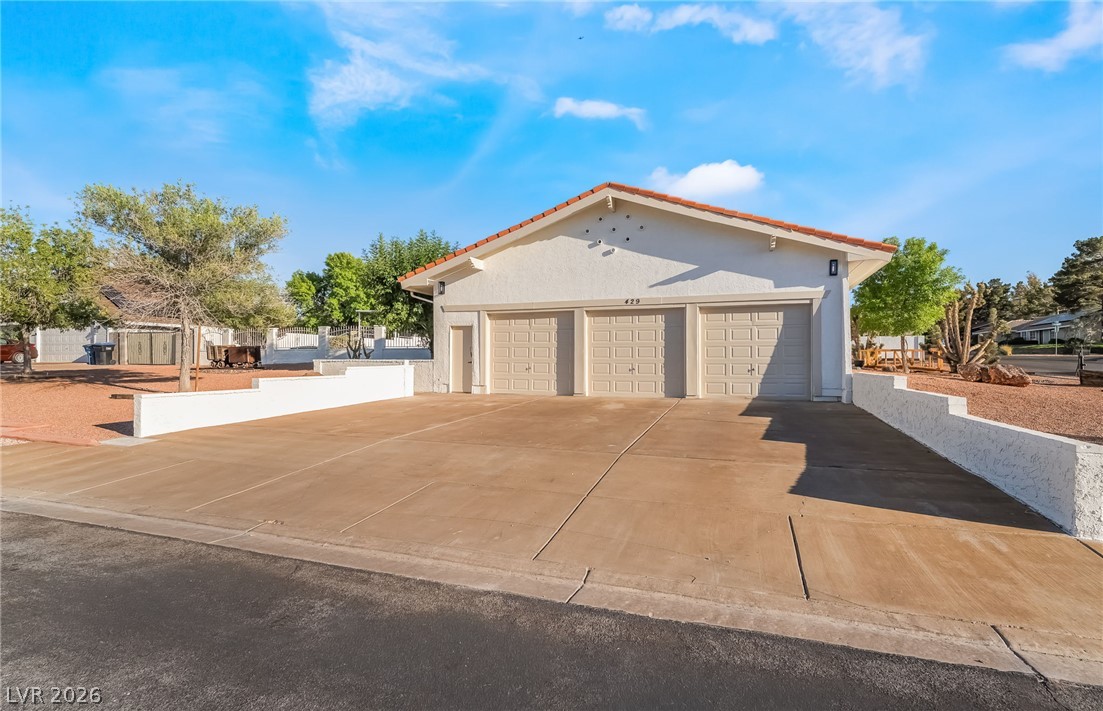 429 Crestway Road Henderson, NV 89015 - Photo 6 of 56 Three garage bays provide abundant vehicle storage, complemented by a spacious concrete driveway.