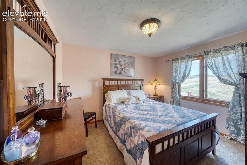 489 Excelsior Road Westcliffe, CO 81252 - Photo 5 of 34 a bedroom with a bed and wooden floor