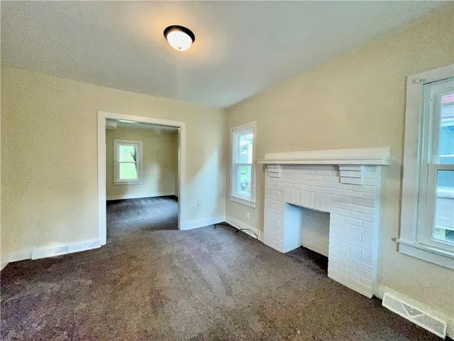 an empty room with fireplace and windows