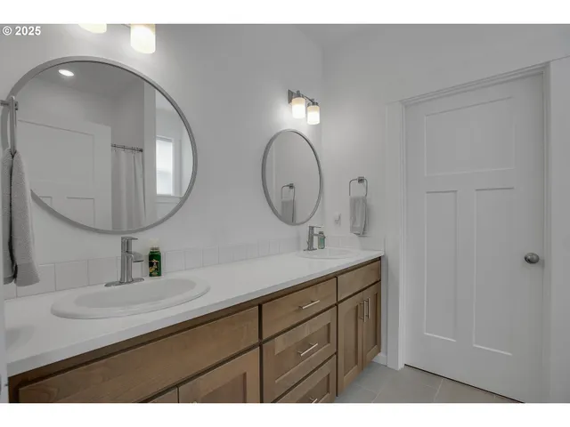 a bathroom with a double vanity sink and a mirror