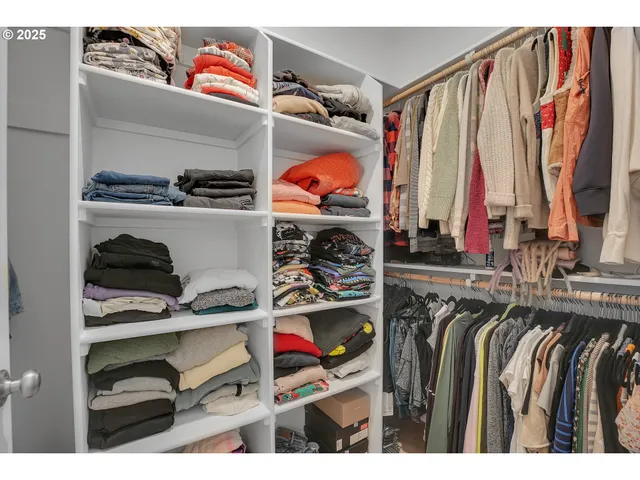 a view of walk in closet with clothes and shoes
