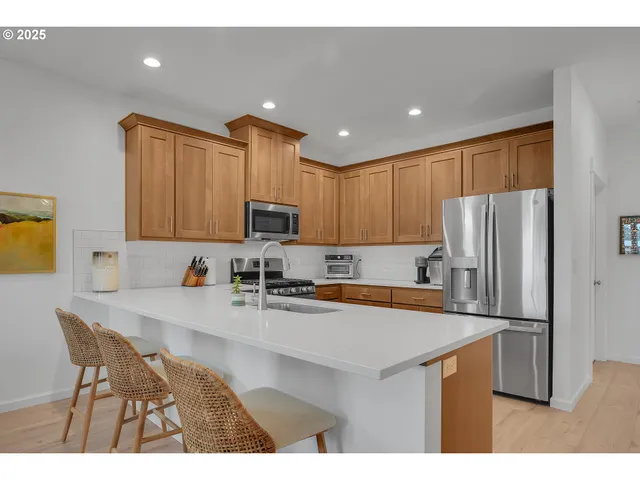 a kitchen with kitchen island a refrigerator sink and wooden cabinets