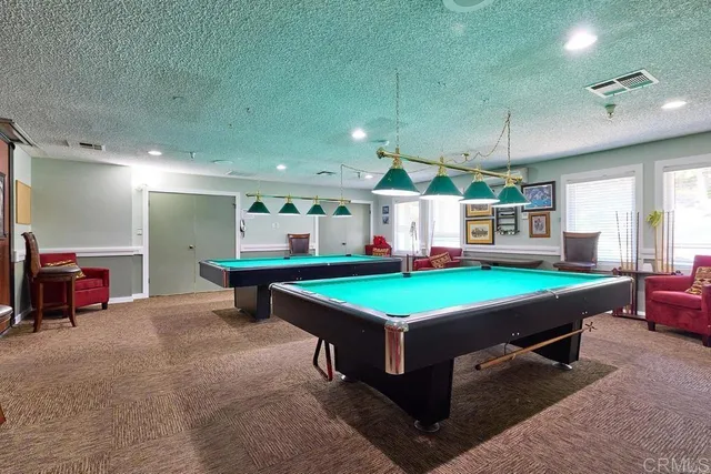 a room with pool table and windows