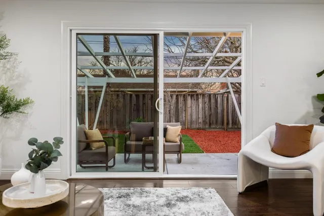 a vase of flowers sitting on a table with wooden floor