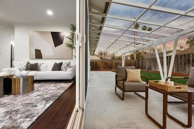 a dining room with wooden floor furniture and kitchen view