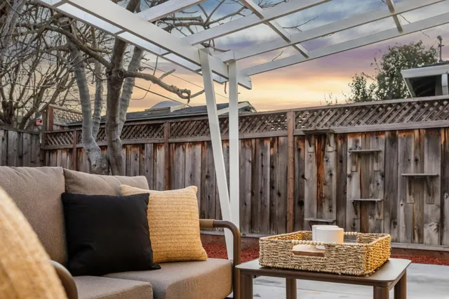 a dining room with wooden floor furniture and kitchen view