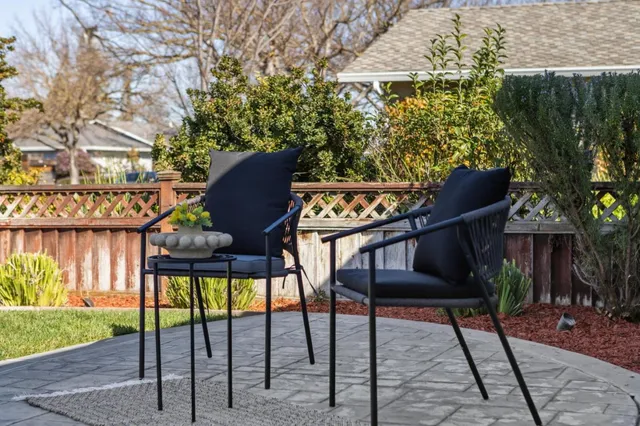 a view of a backyard with table and chairs with wooden fence