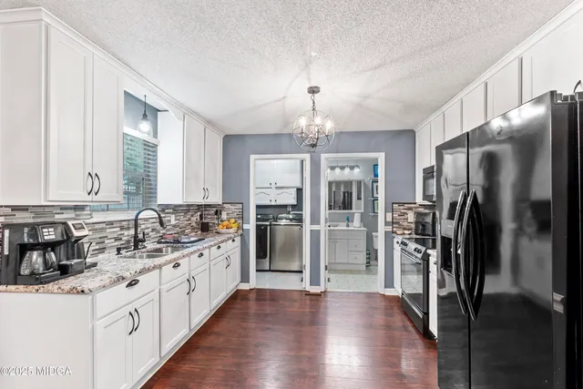 a kitchen with white cabinets and sink
