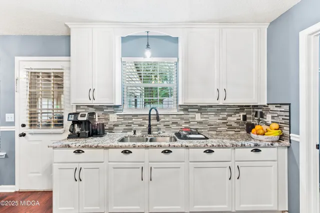 a kitchen with stainless steel appliances white cabinets and a stove top oven