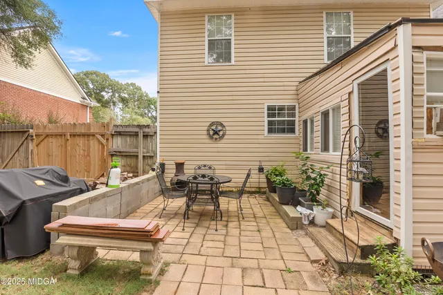 a view of a house with a yard and large tree