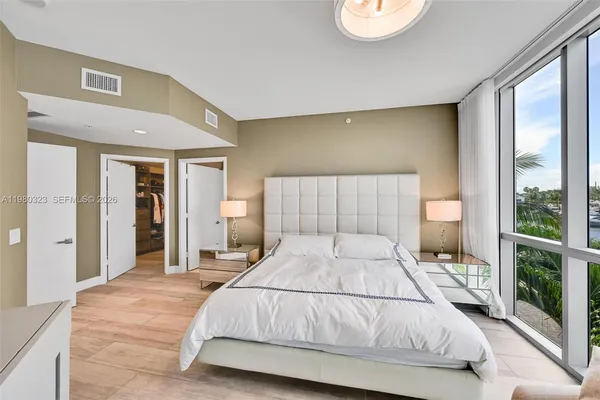 a bedroom with a large bed and a large window