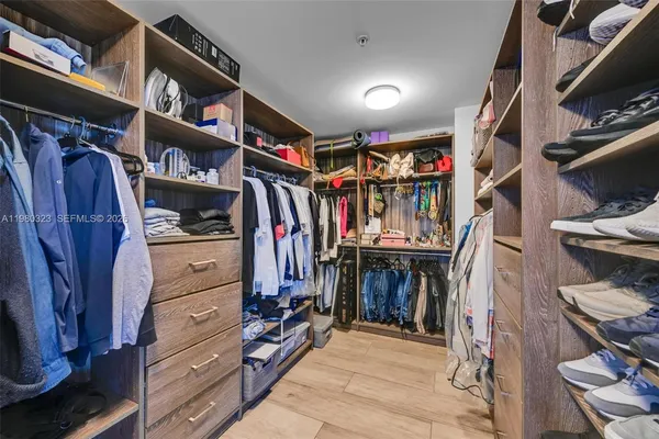a view of walk in closet with clothes and shoes