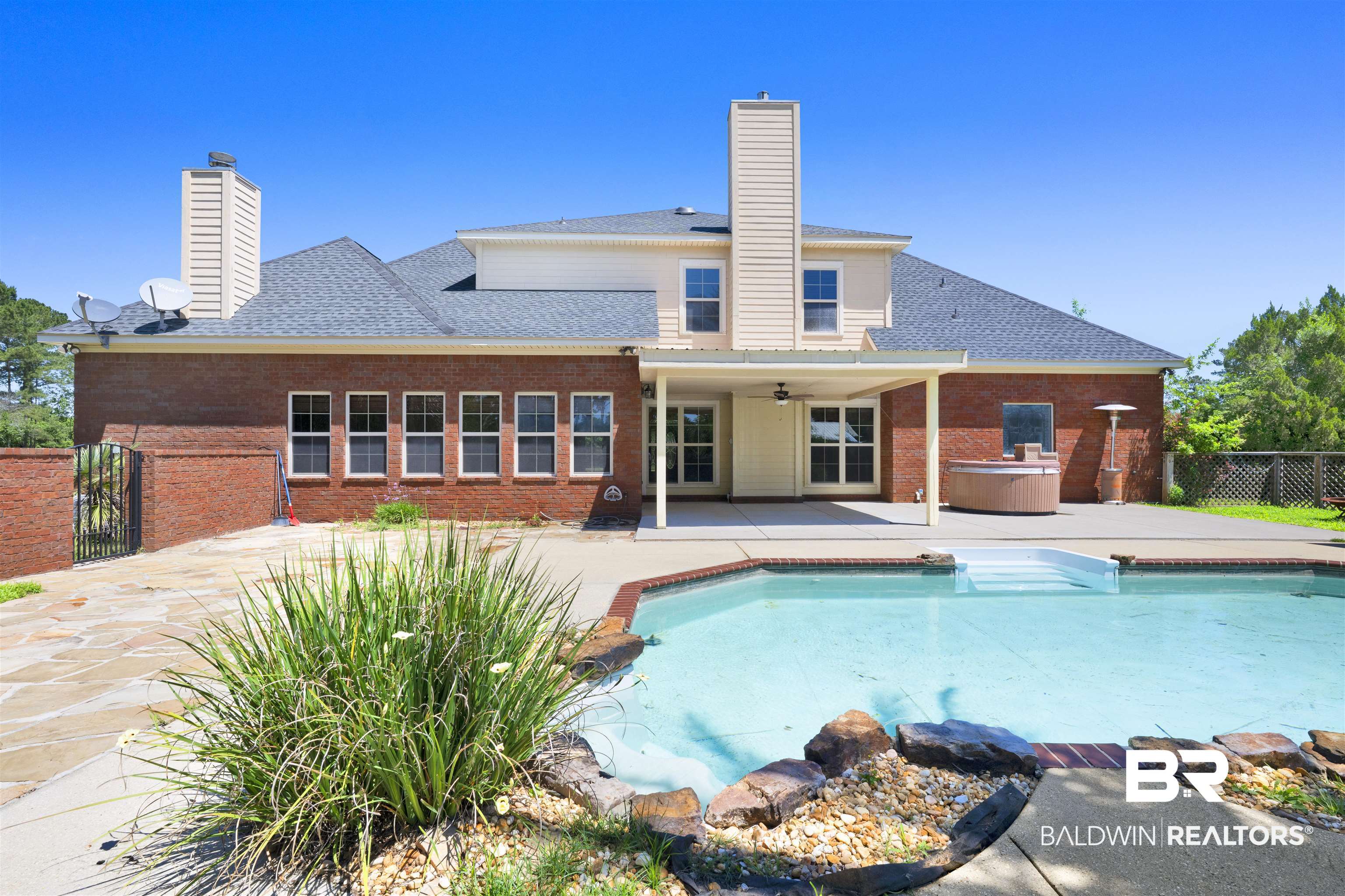 12944 Anna's Way Stapleton, AL 36578 - Photo 24 of 64 Private rear exterior featuring a brick facade, covered patio, integrated swimming pool, and spa