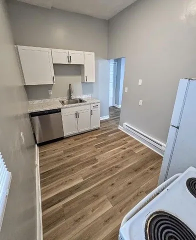 a large white kitchen with a stove a sink and a refrigerator